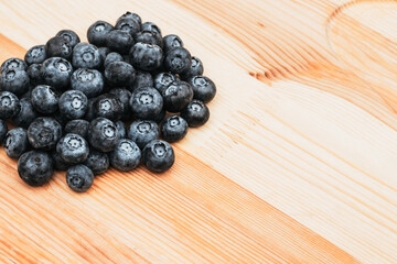 Dark and sweet blueberry on a wooden background. Place for text. Organic and nature concept.