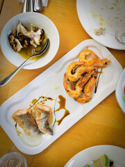 Slices of fresh healthy fish with shrimps, salmon steak a octopus on a plate on a table