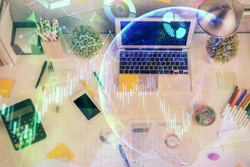 Double exposure of forex chart drawing over table background with computer. Concept of financial research and analysis. Top view.