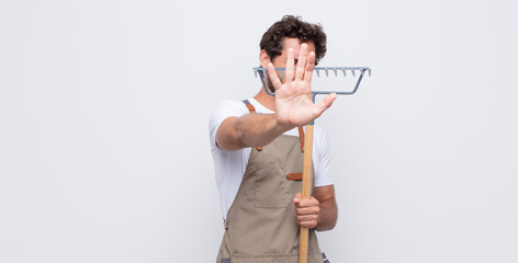 young man covering face with hand and putting other hand up front to stop camera, refusing photos...