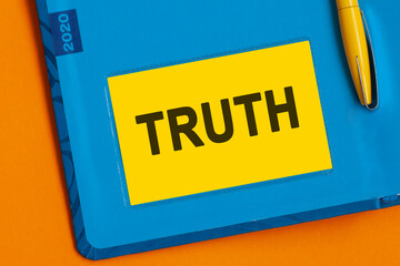Truth the word is written in black letters on the yellow paper for notes.