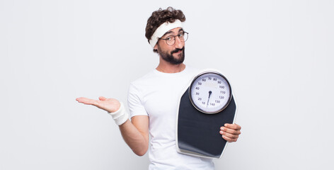 young man feeling happy and smiling casually, looking to an object or concept held on the hand on...
