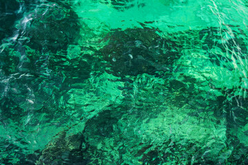 Fototapeta na wymiar Clear turquoise rippled seawater full-screen texture, top view