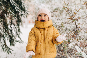 Toddler girl happy with snow day in winter. Playing outside on Christmas holiday