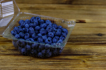 Fresh blueberry in plastic box on a wooden table
