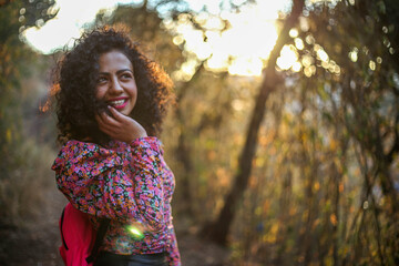 cheerful mexican young woman on the field at sunset, Beautiful woman with gorgeous curly hair in the sunlight