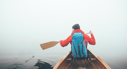 Raer view of the canoeist paddling on the foggy lake, copy space