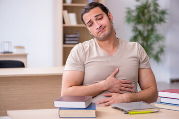 Young male student preparing for exams at library