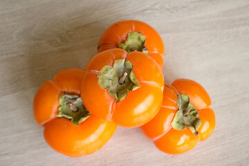 Ripe persimmon isolated on light background, seasonal winter fruit