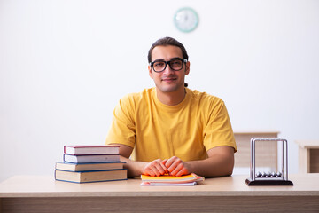 Young male student physics preparing for exams in the classroom