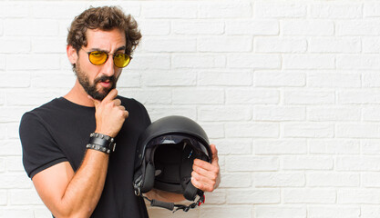 young man looking serious, confused, uncertain and thoughtful, doubting among options or choices