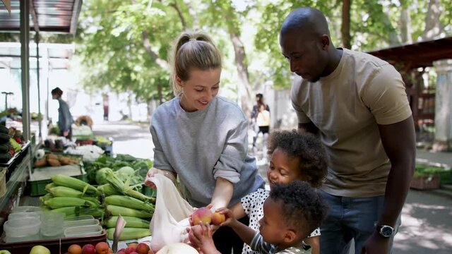 Multiracial family shopping in fruit market.