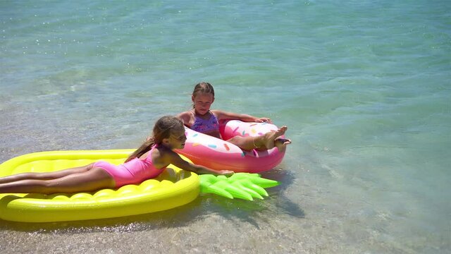 Little girls having fun at tropical beach during summer vacation playing together