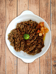 Beef keema with sliced tomatoes in white bowl