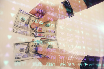 Multi exposure of financial graph drawing hologram and USA dollars bills and man hands. Analysis concept.