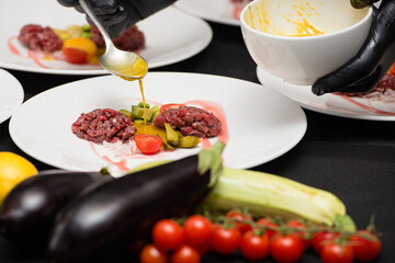 tartare meat with egg, cucumber, tomato and avocado closeup on a white plate.