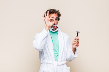 young man smiling happily with funny face, joking and looking through peephole, spying on secrets