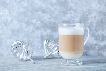 Coffee with milk and Christmas ornaments on bright wooden background. Close up.	