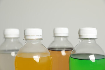 Bottles of soft drinks on grey background, closeup