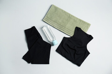 Sportswear, bottle of water and towel on grey background, flat lay. Yoga equipment