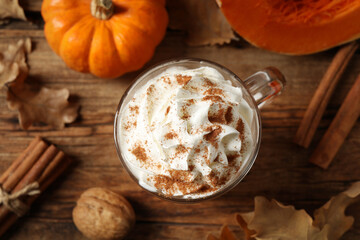 Delicious pumpkin latte on wooden table, top view