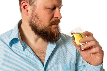 Solid bearded man in shirt tasting whisky studio portrait