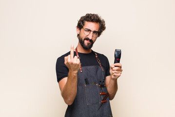 young man feeling angry, annoyed, rebellious and aggressive, flipping the middle finger, fighting...