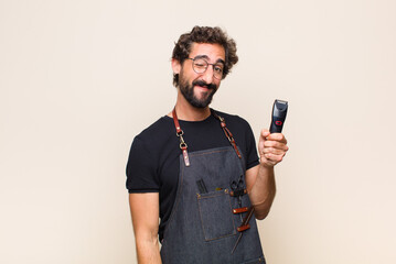 young man looking happy and friendly, smiling and winking an eye at you with a positive attitude