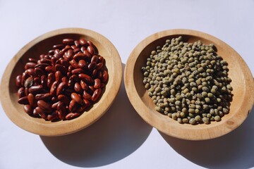 Vigna angularis and Vigna radiata in a wooden plate isolated on a white background.