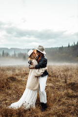 Gorgeous wife with stylish husband on a date, walking at the field, spend weekends together, lovely man hugging pretty woman, enjoy tender moments, healthy relationship concept