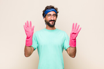 young man smiling and looking friendly, showing number nine or ninth with hand forward, counting...