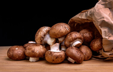 A bunch of mushrooms pouring out of a paper bag