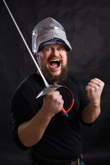 Middle aged bearded man with epee and helmet
