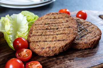 Making tasty vegetarian hamburgers from plant based grilled burgers, fresh bakes buns and organic vegetables