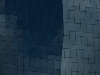 Glass mirrors in skyscraper facade reflecting the sky