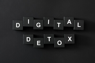 Cubes with phrase DIGITAL DETOX on black background, flat lay