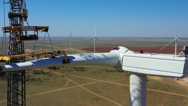 Construction workers are assembling a wind turbine, high altitude work, 4k