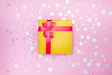 Fototapeta premium gift box on a pink background with sparkles. Flat lay, top view, copy space, still life, background for greeting card