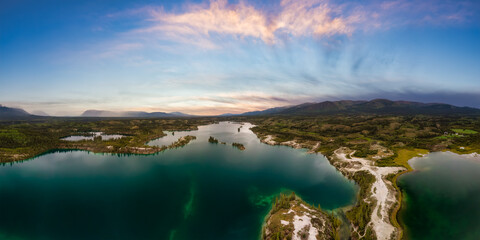 Beautiful Panoramic View of Scenic Lake, Islands and Forest in Canadian Nature. Colorful Sunset Sky. Aerial Done Shot taken near Klondike Highway. Lewes Lake, South of Whitehorse, Yukon, Canada. © edb3_16