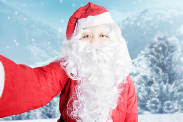 Asian man in Santa costume taking a selfie