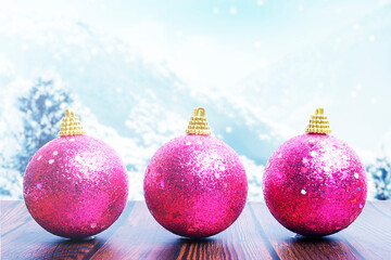Colorful Christmas ball on wooden table with snowfall background