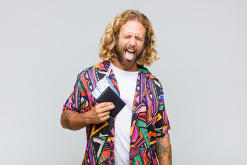 blonde man with cheerful, carefree, rebellious attitude, joking and sticking tongue out, having fun