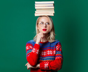 Beautiful woman in Christmas sweater with a books