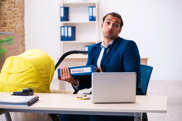 Young male employee looking after kid at workplace