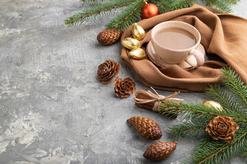 Christmas or New Year composition. Decorations, cones, fir and spruce branches, cup of coffee, on a gray concrete background. Side view, copy space.