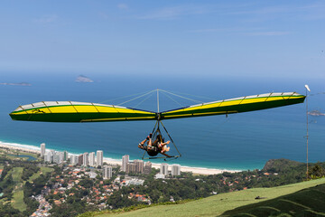 Hang glider taking off to fly over the beach