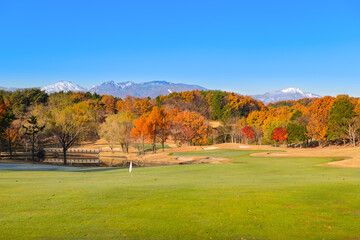 Fototapeta na wymiar 日本　早朝で朝霜の紅葉のゴルフ場と雪山