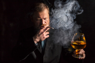 Solid confident bearded man in suit with glass of whisky and cigar with fume