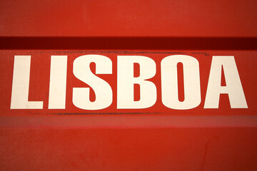 White letters saying Lisboa or Lisbon in Portuguese on red metallic background. Portugal