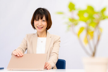 定時なので業務を終わらせノートPCを閉める女性【2020】	
